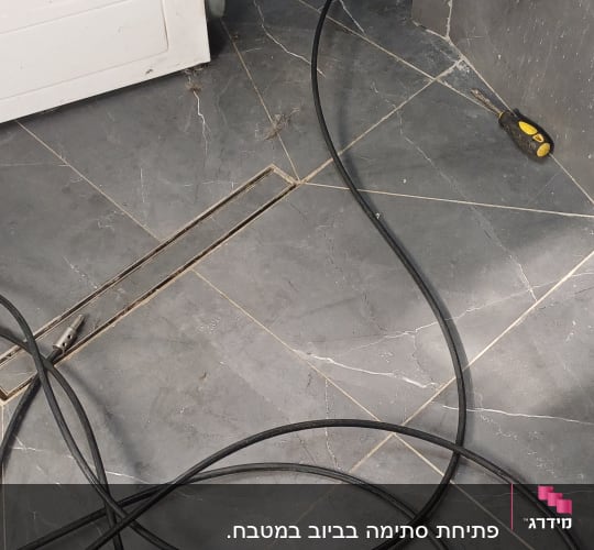 כבל וכלי עבודה ליד מכונת כביסה בחדר אמבטיה